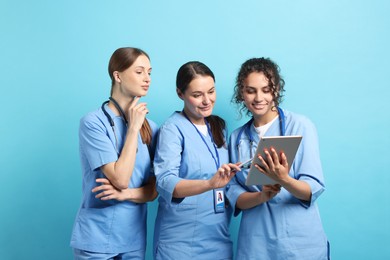 Photo of Group of medical students with tablet on light blue background