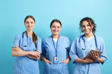 Photo of Group of medical students with tablet on light blue background
