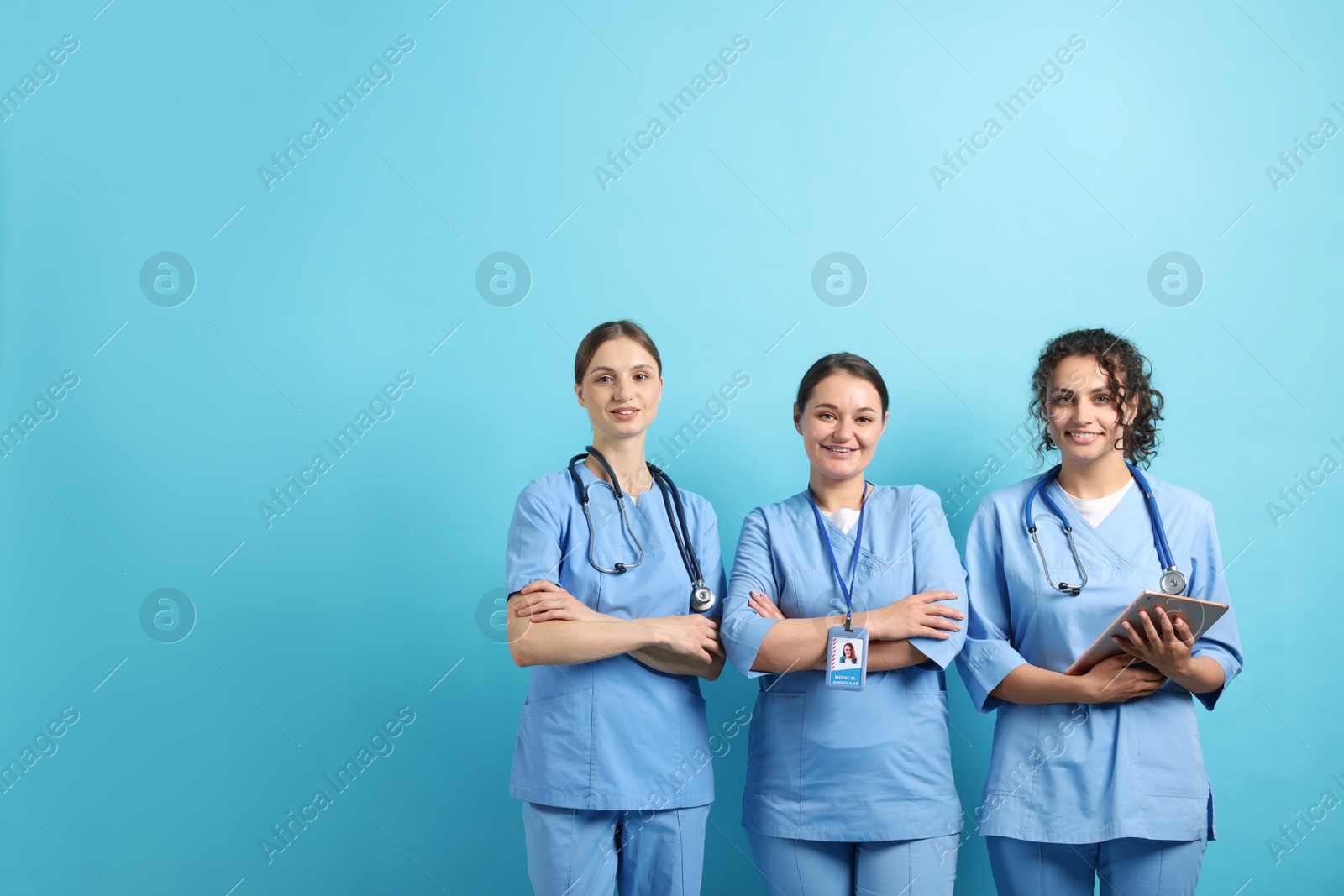 Photo of Group of medical students with tablet on light blue background