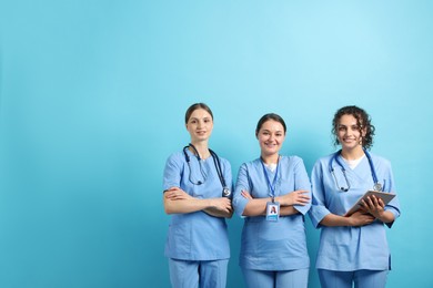 Photo of Group of medical students with tablet on light blue background