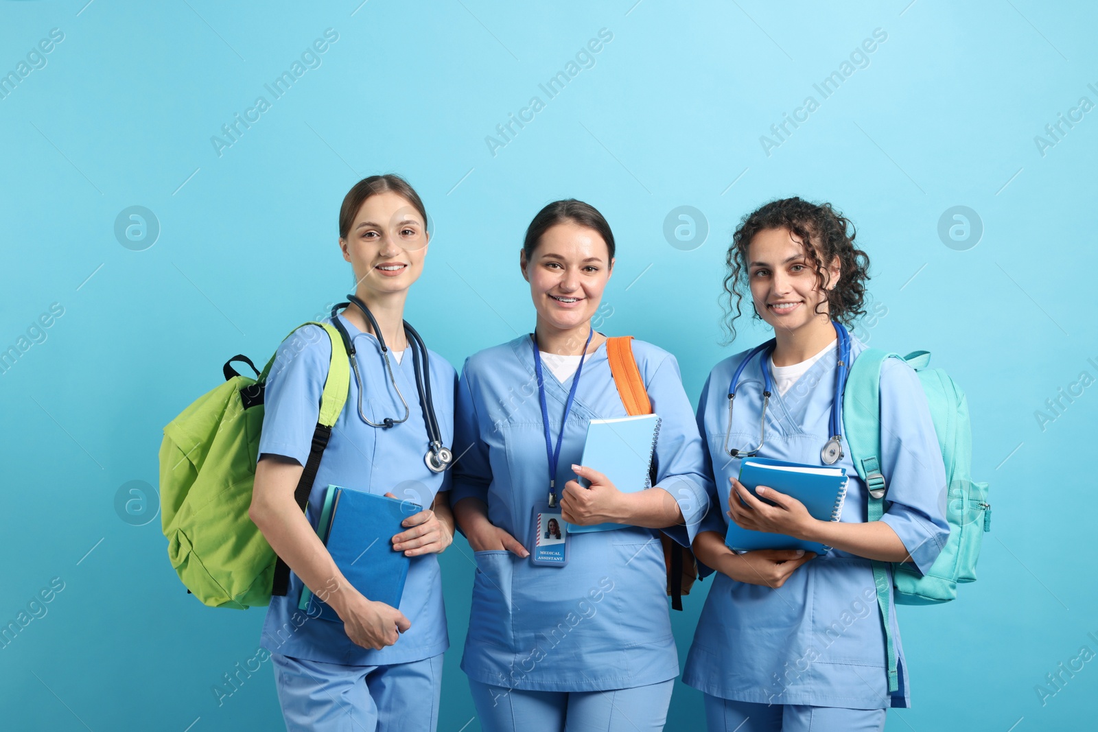Photo of Group of medical students with books on light blue background