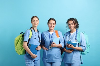 Photo of Group of medical students with books on light blue background
