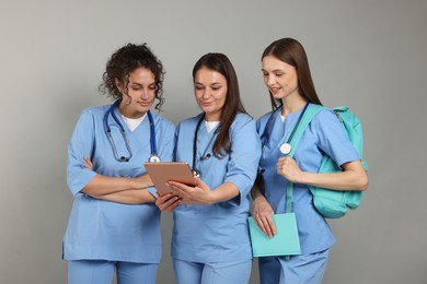 Photo of Group of medical students with tablet on light grey background