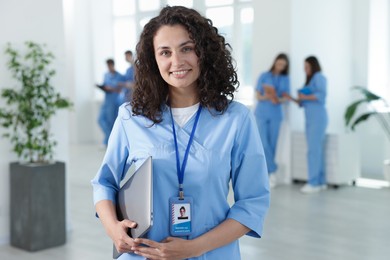Photo of Medical student in uniform with laptop indoors, selective focus