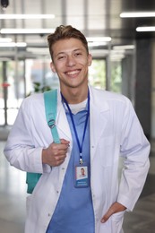 Photo of Medical student in uniform with backpack indoors