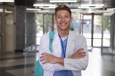 Photo of Medical student in uniform with backpack indoors