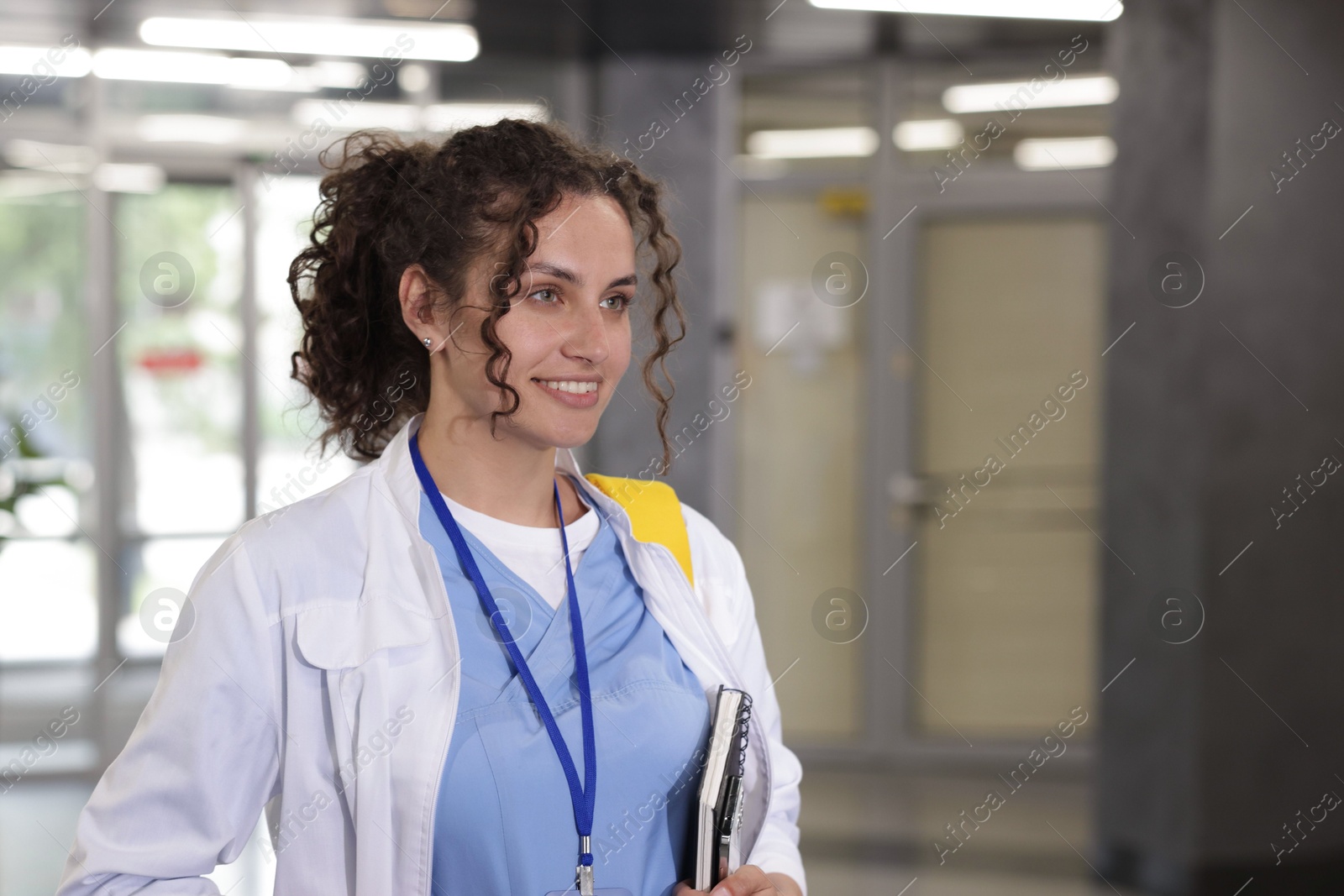 Photo of Medical student in uniform with notebook indoors