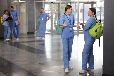 Photo of Medical students in uniforms indoors, selective focus