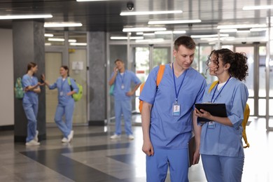 Photo of Medical students in uniforms indoors, selective focus