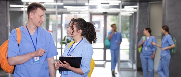 Photo of Medical students in uniforms indoors, selective focus