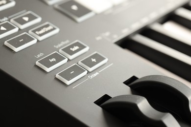 Photo of MIDI keyboard with buttons and faders, closeup