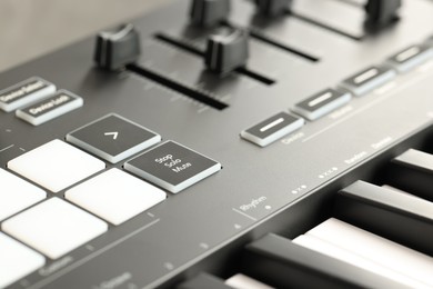 Photo of MIDI keyboard with buttons and faders, closeup