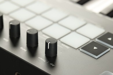 Photo of MIDI keyboard with buttons and faders, closeup