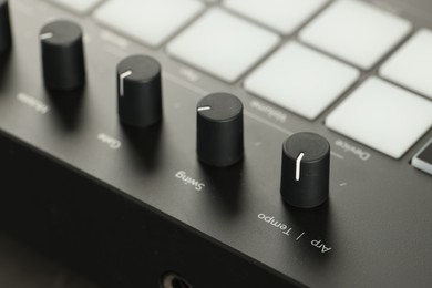 Photo of MIDI keyboard with buttons and faders, closeup