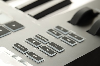 Photo of MIDI keyboard with buttons and faders, closeup