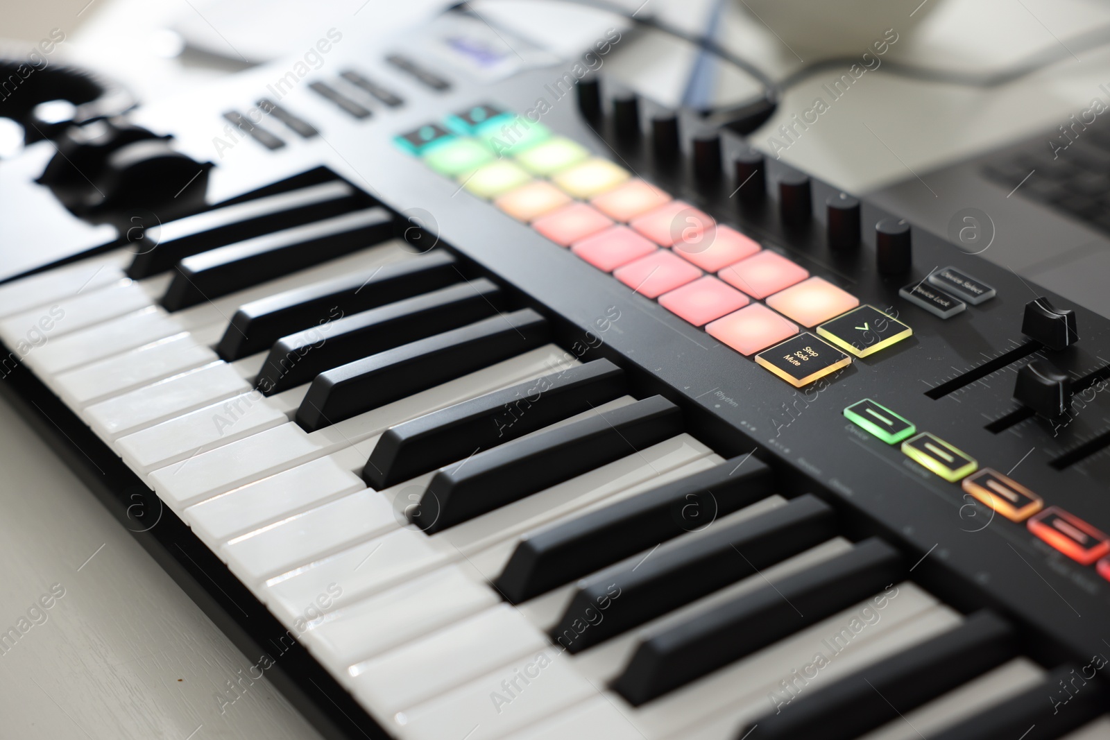 MIDI keyboard on white wooden table, closeup Photo of MIDI keyboard on white wooden table, closeup