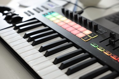 Photo of MIDI keyboard on white wooden table, closeup