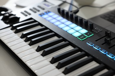 Photo of MIDI keyboard on white wooden table, closeup