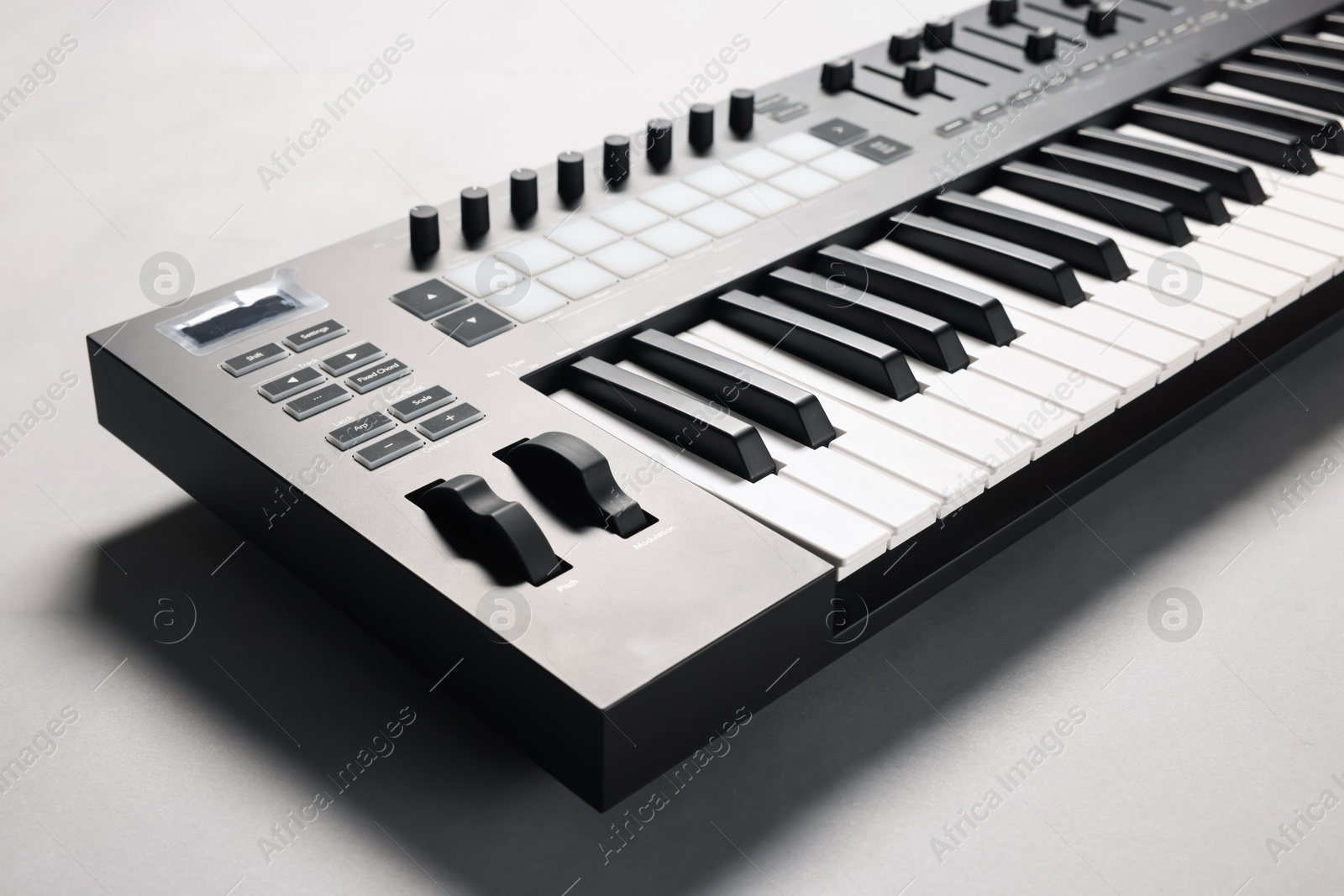 Photo of One portable MIDI keyboard on grey background, closeup