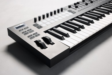 Photo of One portable MIDI keyboard on grey background, closeup