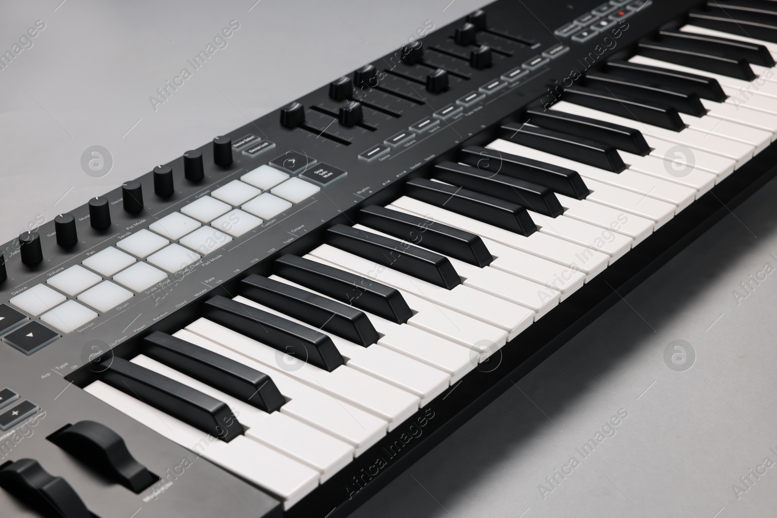 Photo of One portable MIDI keyboard on grey background, closeup