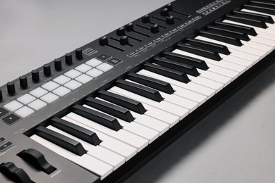 Photo of One portable MIDI keyboard on grey background, closeup