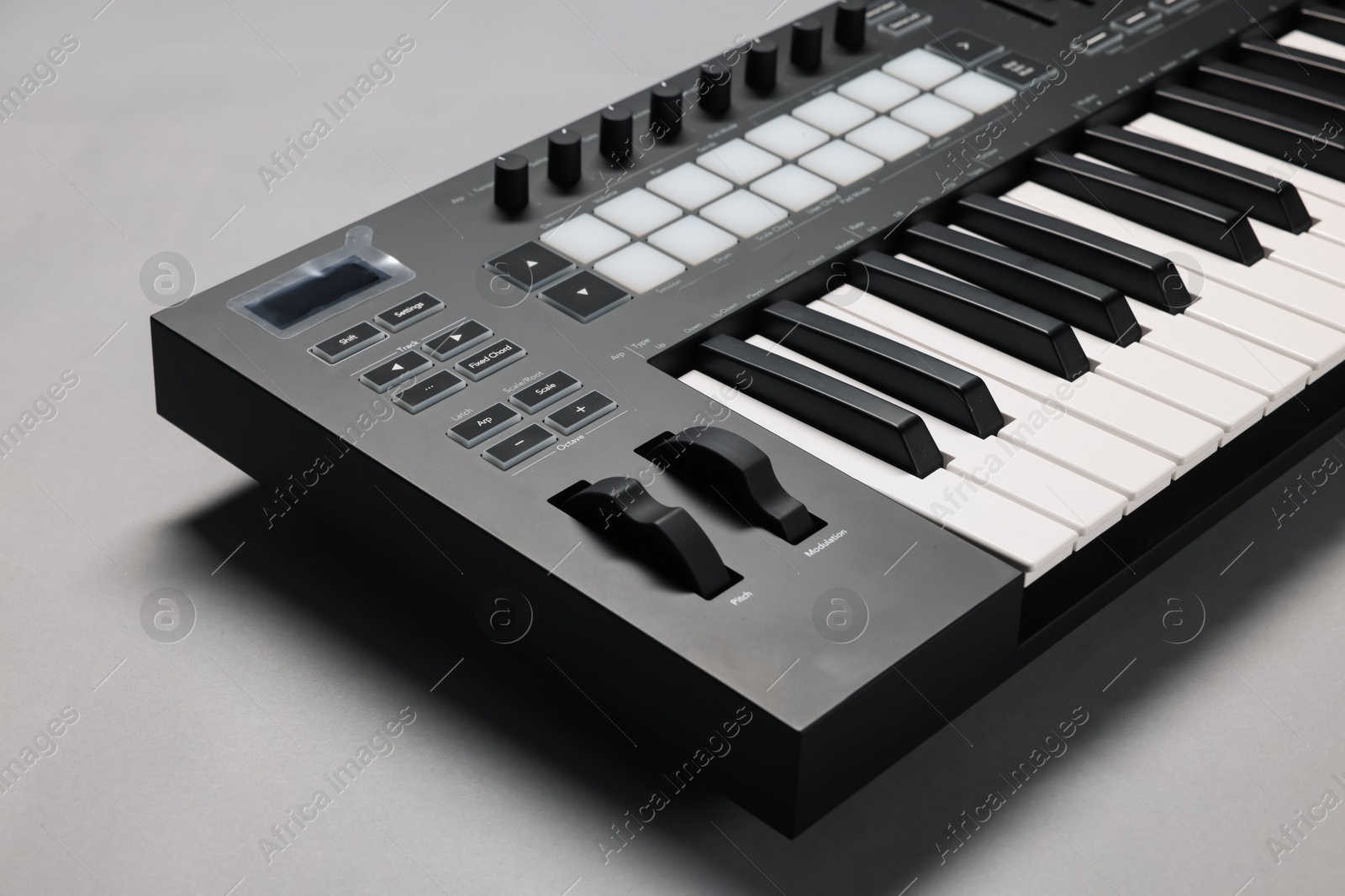 Photo of One portable MIDI keyboard on grey background, closeup