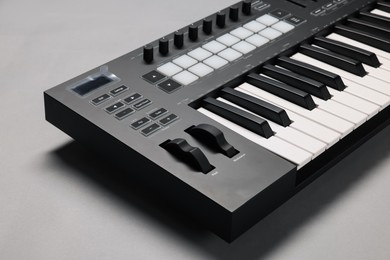 Photo of One portable MIDI keyboard on grey background, closeup