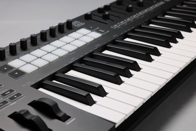 Photo of One portable MIDI keyboard on grey background, closeup