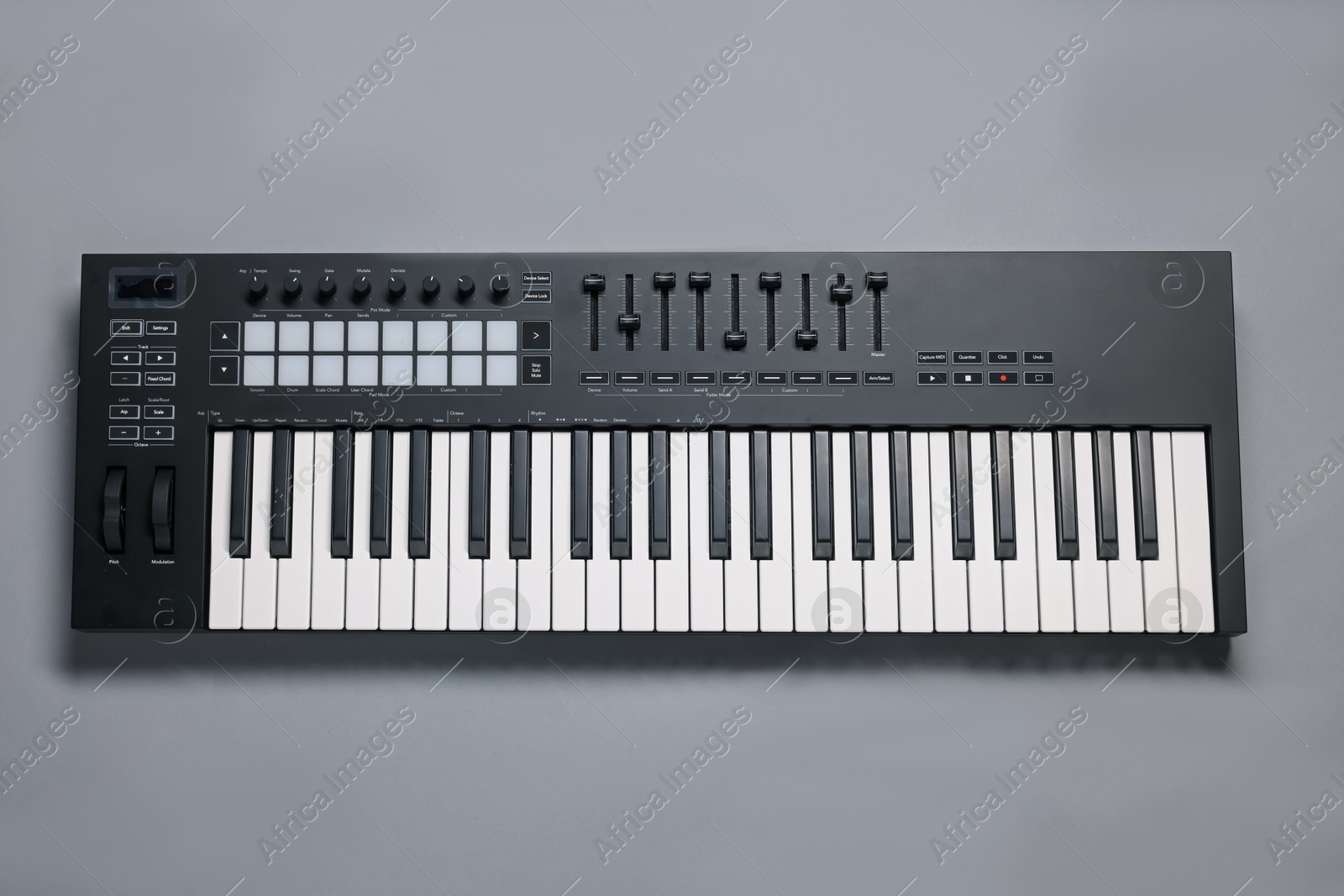Photo of One portable MIDI keyboard on grey background, top view