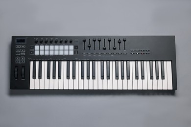 Photo of One portable MIDI keyboard on grey background, top view