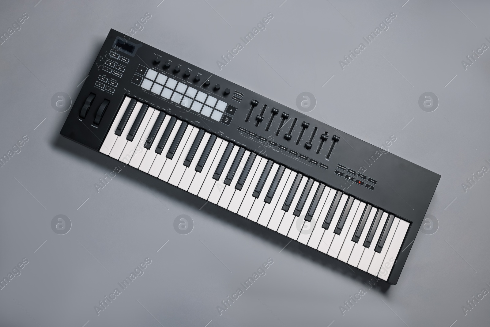 Photo of One portable MIDI keyboard on grey background, top view