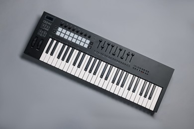 Photo of One portable MIDI keyboard on grey background, top view