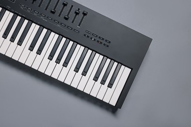 Photo of One portable MIDI keyboard on grey background, top view