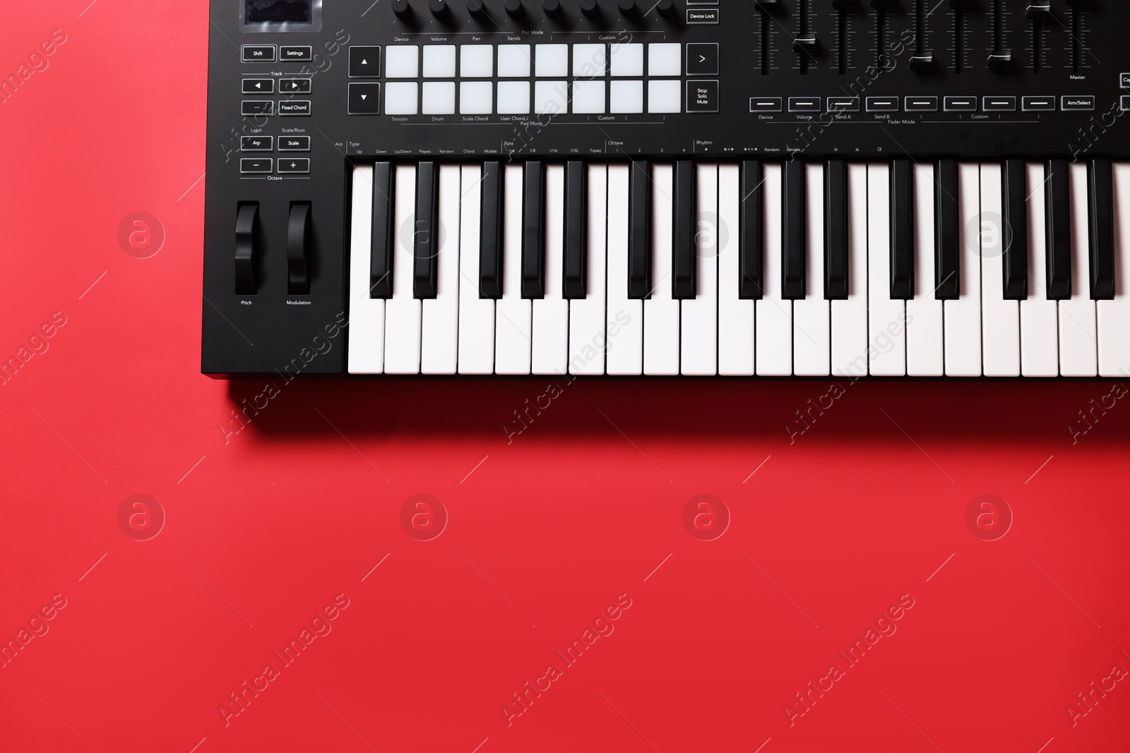Photo of One portable MIDI keyboard on red background, top view