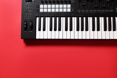 Photo of One portable MIDI keyboard on red background, top view