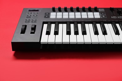 Photo of One portable MIDI keyboard on red background, closeup