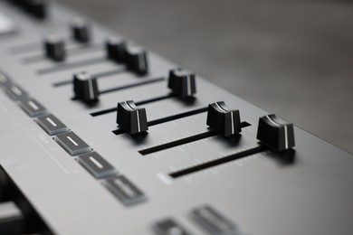 Photo of MIDI keyboard with faders on table, closeup