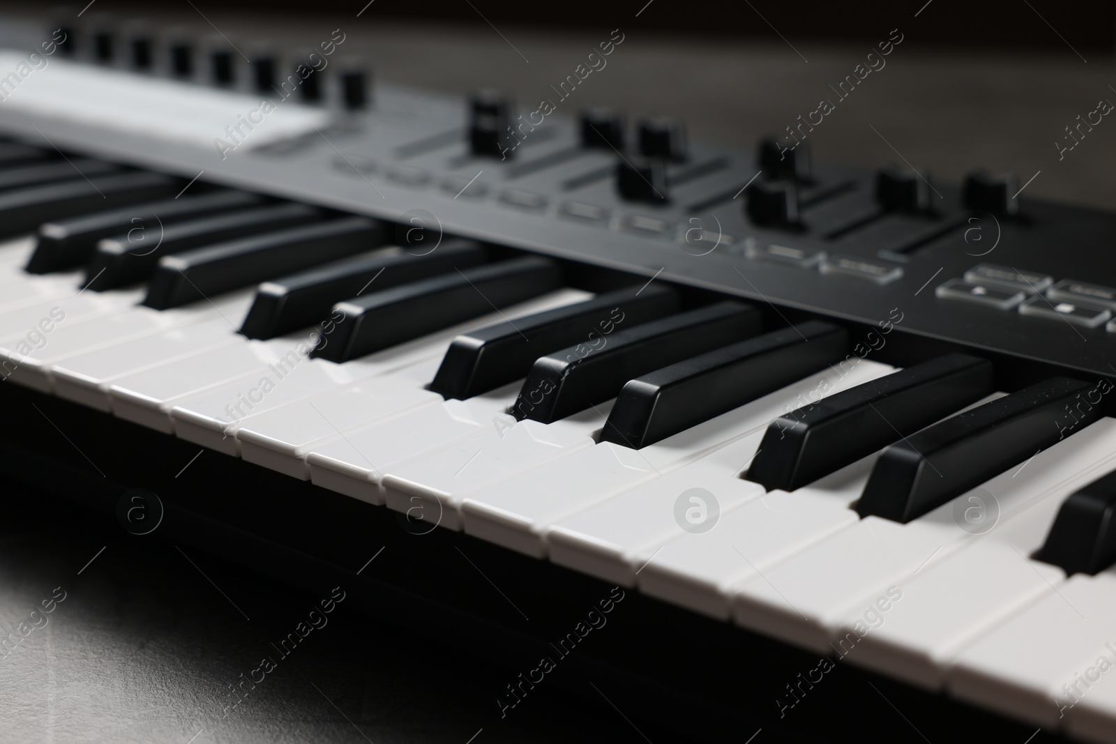 Photo of One portable MIDI keyboard on grey table, closeup