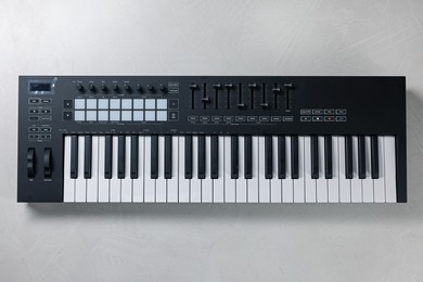Photo of One portable MIDI keyboard on white table, top view