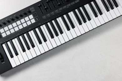 Photo of One portable MIDI keyboard on white table, top view. Space for text