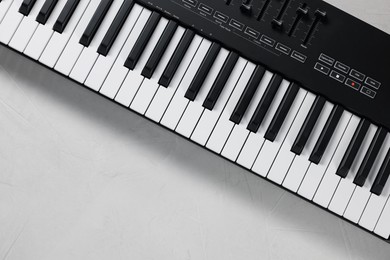 Photo of One portable MIDI keyboard on white table, top view. Space for text