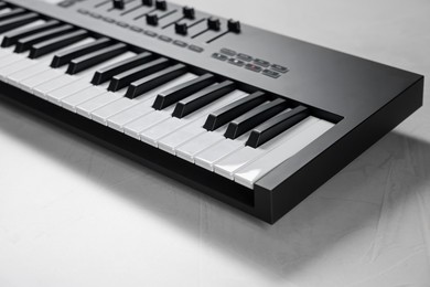 Photo of One portable MIDI keyboard on white table, closeup