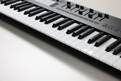 Photo of One portable MIDI keyboard on white table, closeup