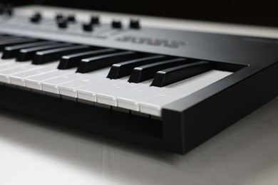 Photo of One portable MIDI keyboard on white table, closeup