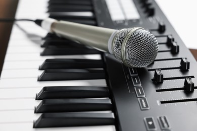Photo of MIDI keyboard and microphone on table, closeup