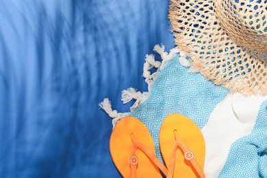 Photo of Beach accessories on blue background, flat lay. Space for text