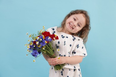 Photo of Cute little girl with bouquet of beautiful flowers on light blue background