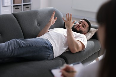 Photo of Professional psychologist working with patient in office, selective focus