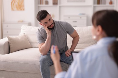 Photo of Professional psychologist working with patient in office, selective focus